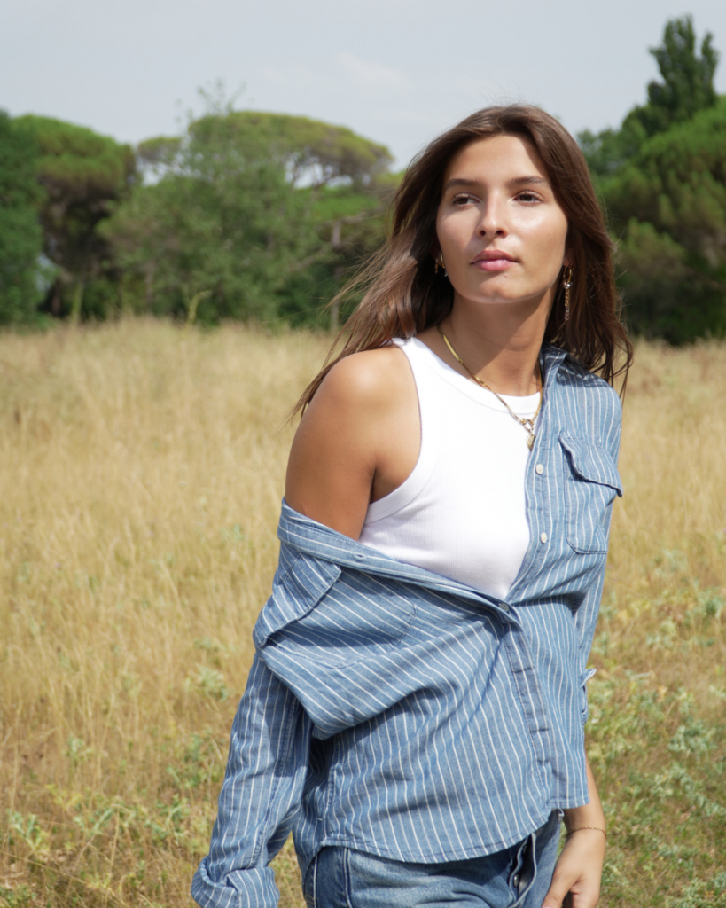 Femme portant une chemise Levi's rayée bleue et blanche en extérieur